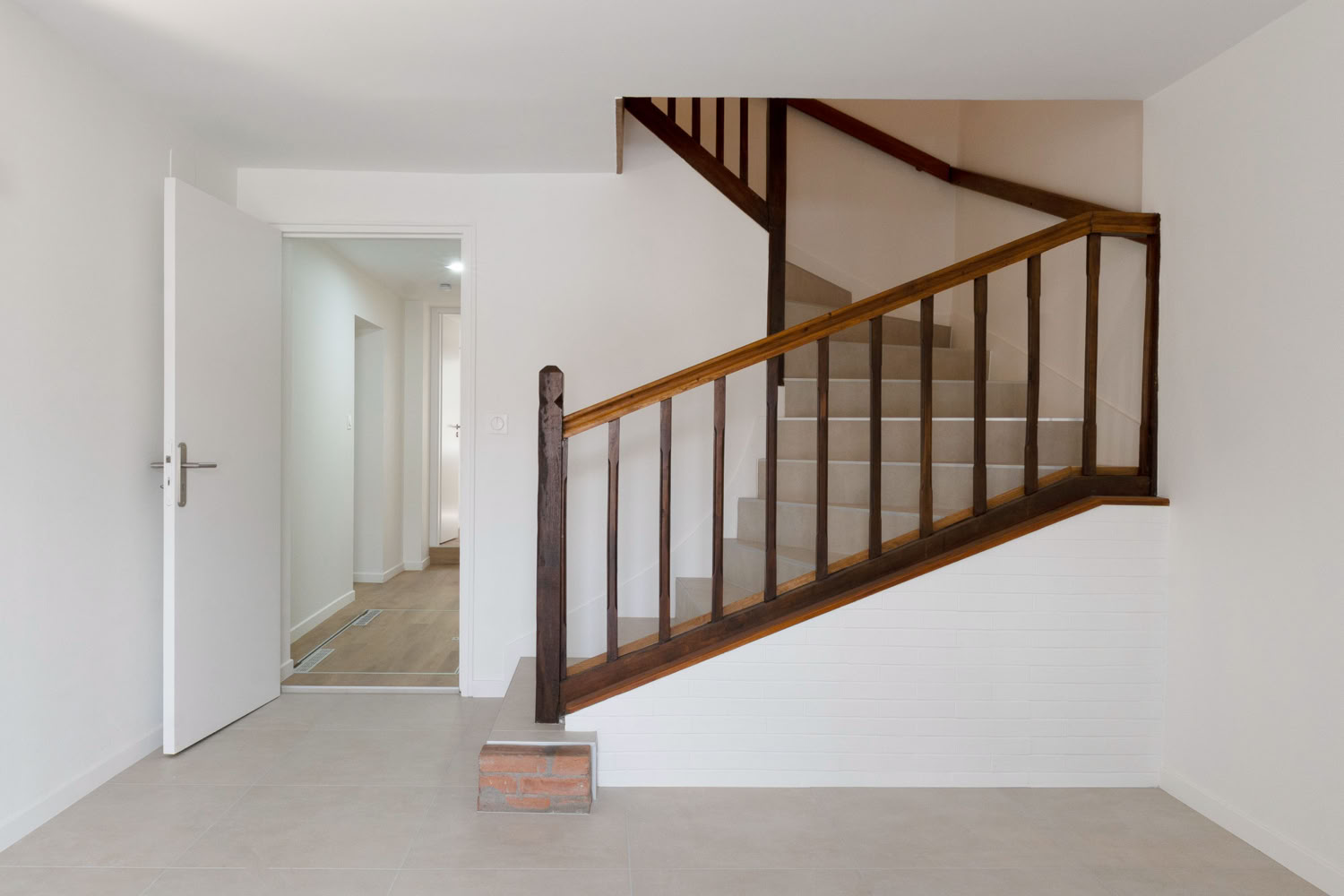 Entrée épurée et lumineuse avec escalier en bois d'origine, rénovation maison de village Metz.