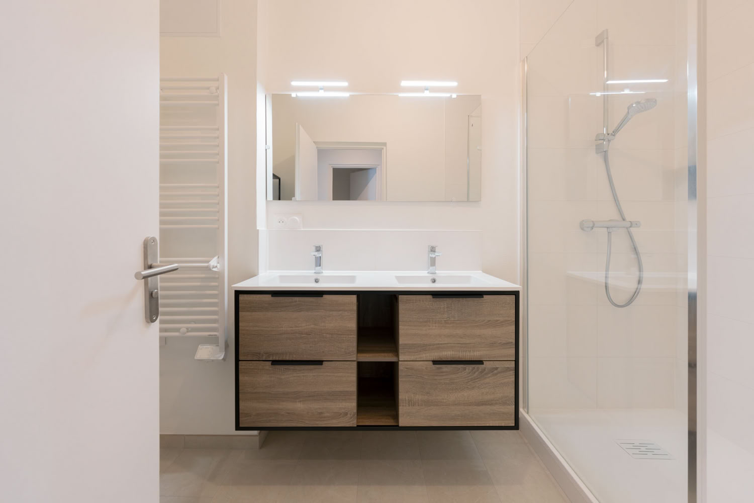 Aménagement salle de bain moderne avec double vasque bois et douche à l'italienne à Metz.