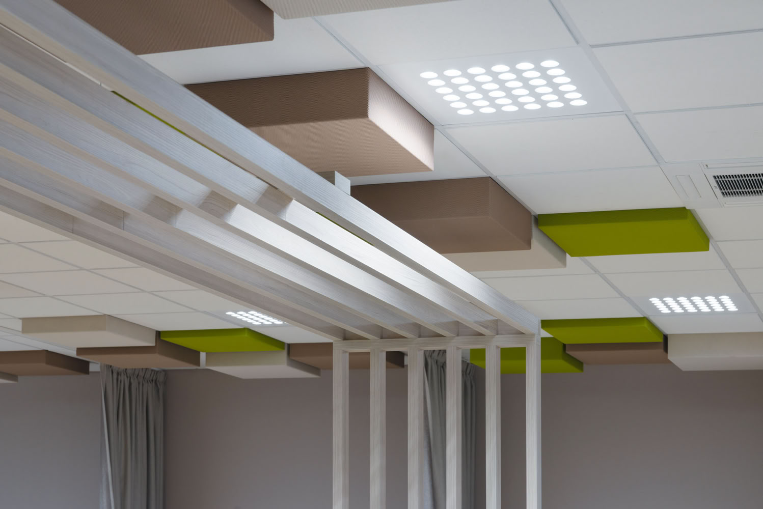 Traitement acoustique design au plafond avec panneaux suspendus verts et bois, rénovation technique ERP à Metz. 