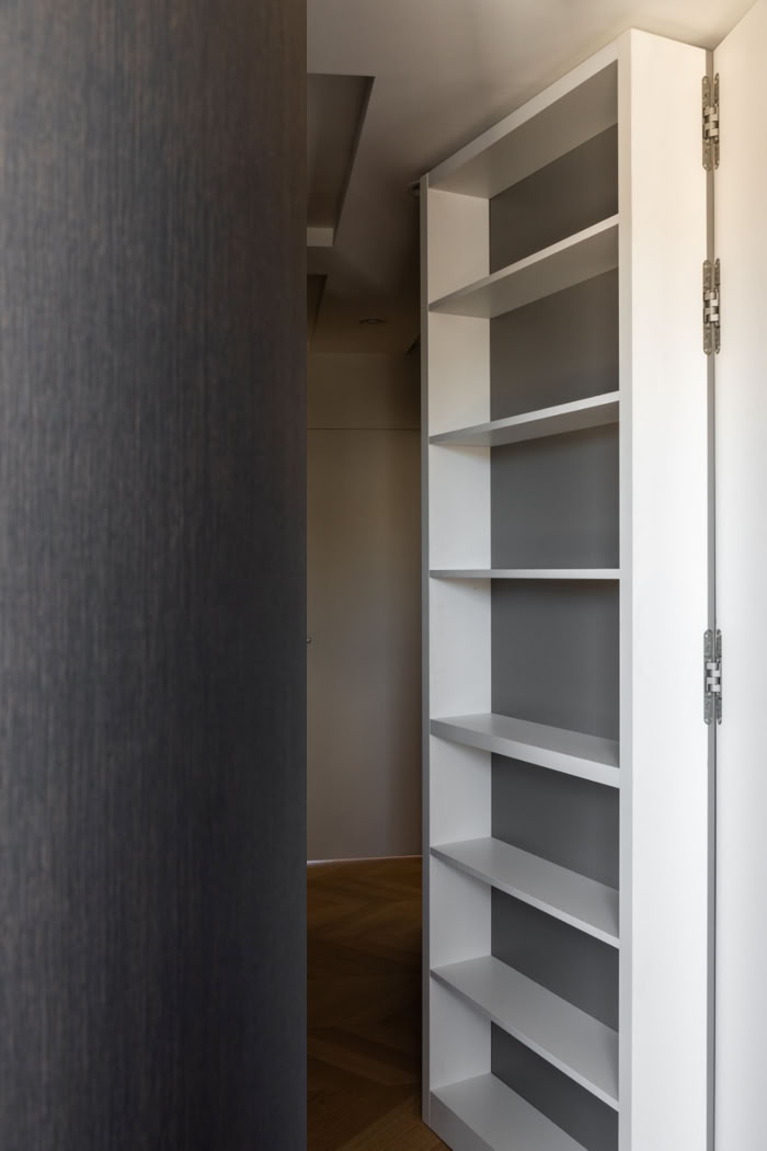 Zoom sur la porte dérobée sur mesure, illustrant la précision de la menuiserie intérieure.