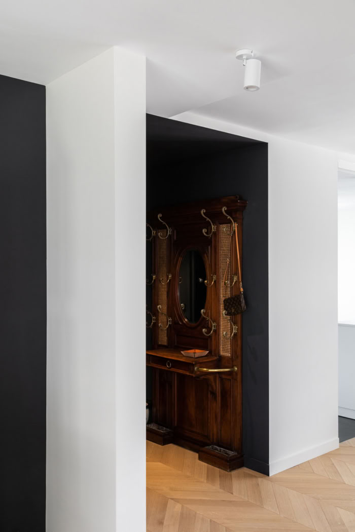 Aménagement d'une entrée avec vestiaire et miroir anciens, créant un effet de surprise dès l'arrivée.